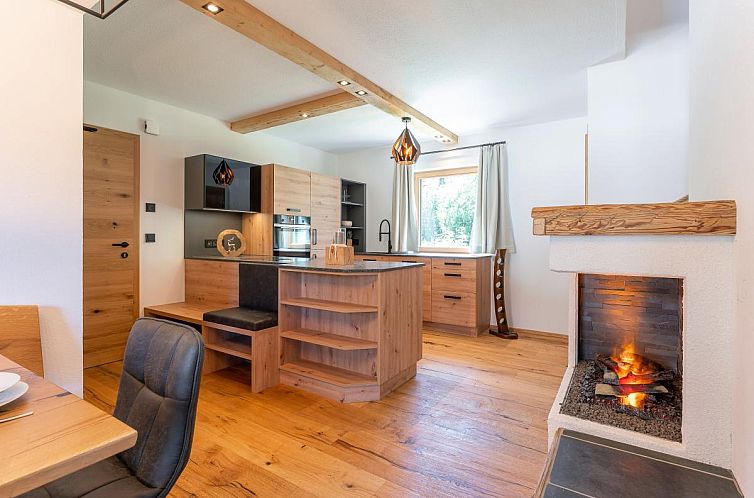 Binnenruimte van AlmApARTment Mauterndorf Pichl 8-2, vakantiehuis in Salzburg, Oostenrijk, met open haard en stijlvolle keuken.