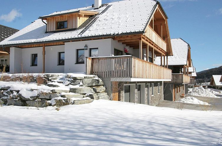 Gemuetliches Ferienhaus Sonnenalm in Mauterndorf, Salzburg, umgeben von Schnee und Bergen.