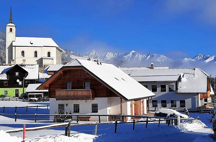 Sfeervolle Wolfgangchalet A in het winterse landschap van Mauterndorf, Salzburg, met uitzicht op de majestueuze bergen.
