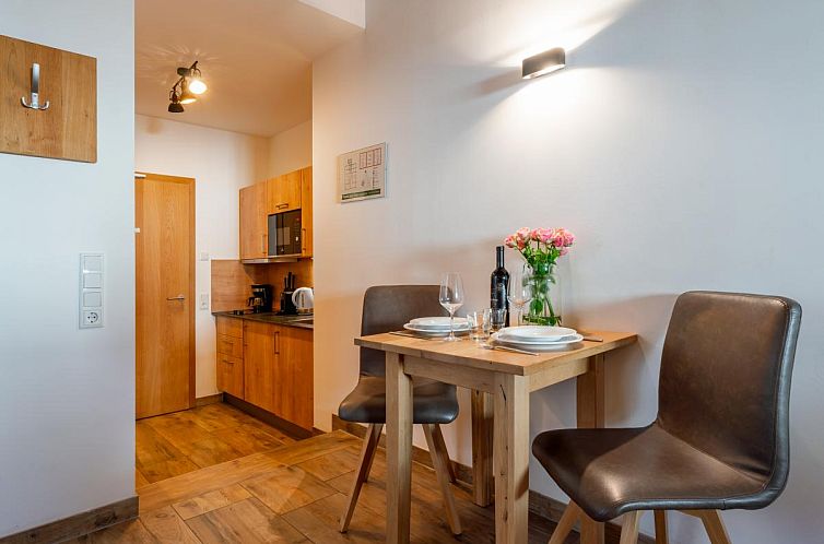 Atmosphaerischer Innenbereich der Tauern Suites Mitterwirt TOP 124, Ferienunterkunft in Piesendorf, Salzburg mit gemuetlicher Essecke und Kueche.