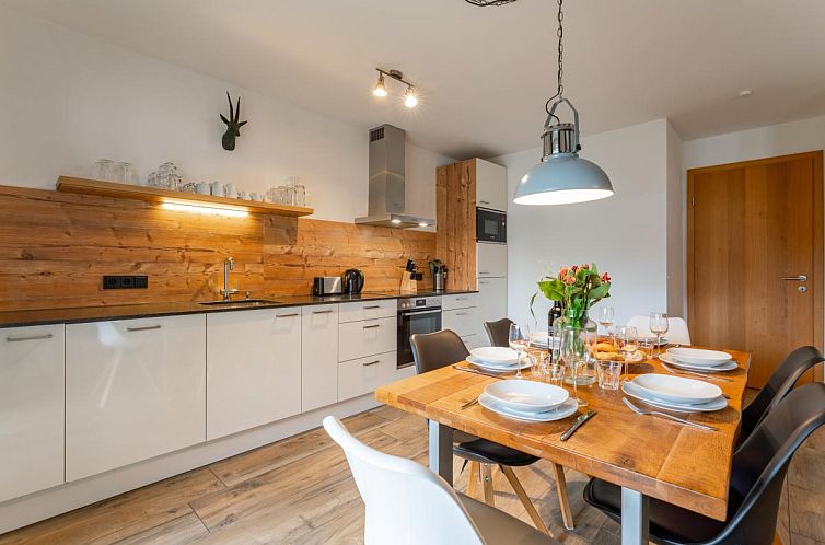 Gezellige eetruimte in Tauern Suites Mitterwirt TOP 202, vakantieverblijf in Piesendorf, Salzburg, met moderne keukenfaciliteiten.