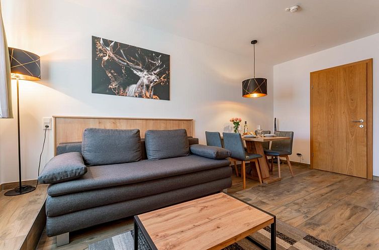 Stylish interior space of Tauern Suites Mitterwirt TOP 125, vacation accommodation in Piesendorf, Salzburg with cozy sitting area and dining area.