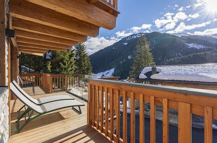 Entspannen Sie sich auf dem Sonnenbalkon des Hauses am Hang in Hinterglemm, Salzburg, mit einem herrlichen Alpenpanorama.