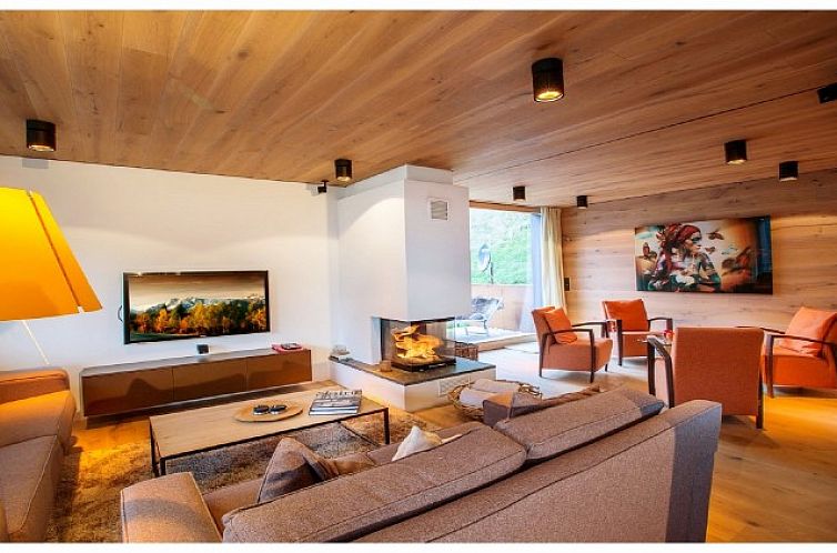 Luxe binnenruimte van Chalet Senningerblick, Bramberg am Wildkogel, Salzburg, met warme houten accenten en sfeervolle open haard.