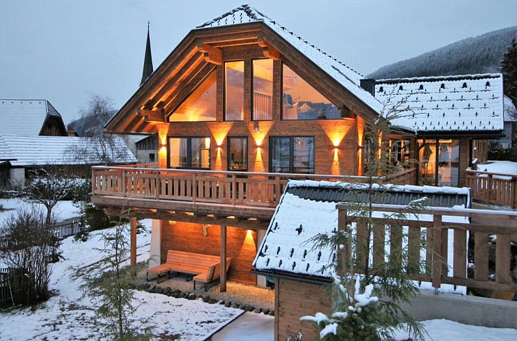 Verlichte Alpinn Wellness 1 chalet in de winterse natuur van Sankt Margarethen im Lungau, Salzburg. Perfect vakantiehuis voor ontspanning.