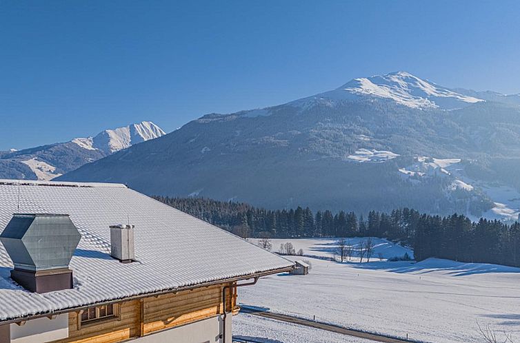 Uitzicht op de besneeuwde bergen vanaf chalet Premium XL in Hollersbach im Pinzgau, Salzburg, Oostenrijk.