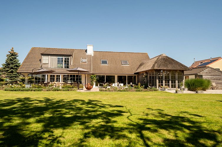 Vakantiehuis Villa Rosetree met sauna en pooltafel in De Haan, Belgische kust, biedt een ruime tuin en zonnig terras voor ontspanning.