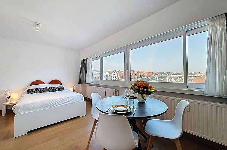 Gemuetliches Schlafzimmer im Apartment Soley mit Blick auf De Haan an der belgischen Kueste. Komfortable Unterkunft mit Essbereich und viel Tageslicht.