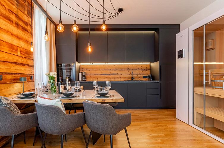 Stilvolles Interieur der Zirbennest Sonnenalpe Nassfeld, Ferienunterkunft in Hermagor, Kaernten, mit warmen Holzakzenten und moderner Einrichtung.