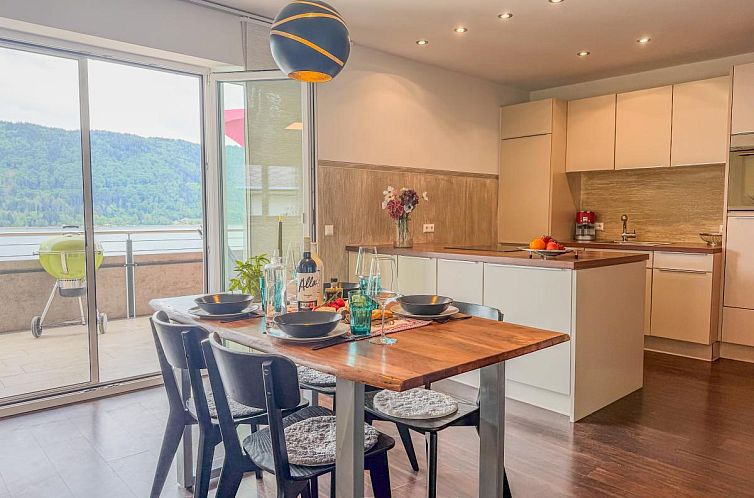 Das Appartement Franz in Sattendorf, Kaernten, bietet einen atemberaubenden Blick auf den ruhigen See, perfekt fuer Naturliebhaber.