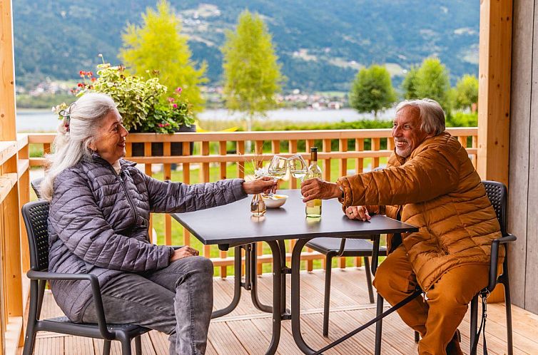 Relax on the veranda of Enzian Waterfront, a vacation home in Ossiach, Carinthia, with stunning views of Austrian nature.