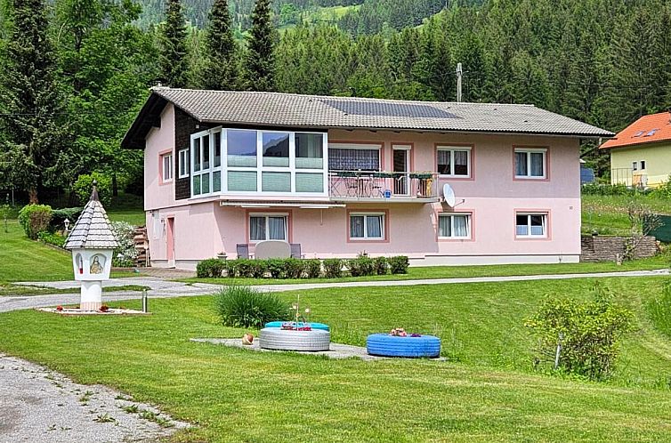 Winterlandschaft am Ferienhaus Mangartblick in Arriach, Kaernten mit verschneiten Waeldern.