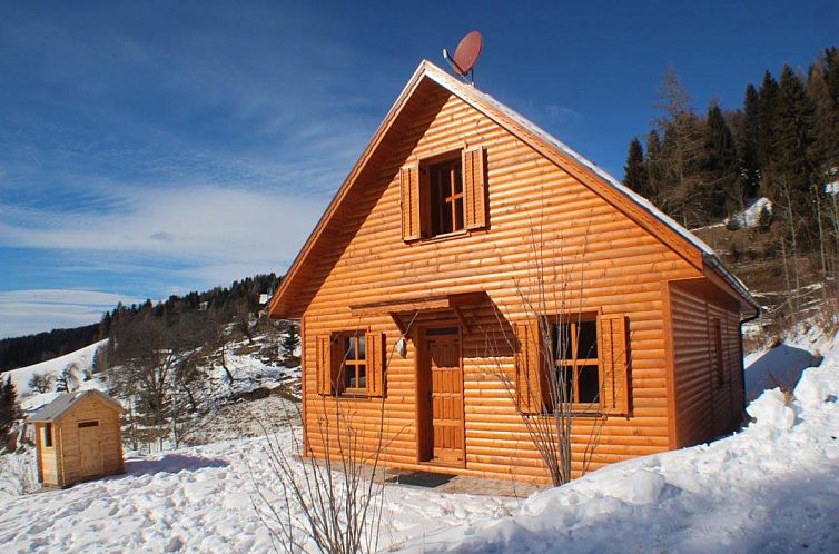 Holzferienhaus Sternenchalet in Liebenfels, Kaernten, in einer malerischen, verschneiten Berglandschaft gelegen.
