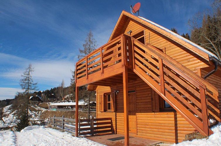 Gezellig vakantiehuis Karawankenpanorama S in Liebenfels, Karinthie, met houten terras en winterse bergomgeving.