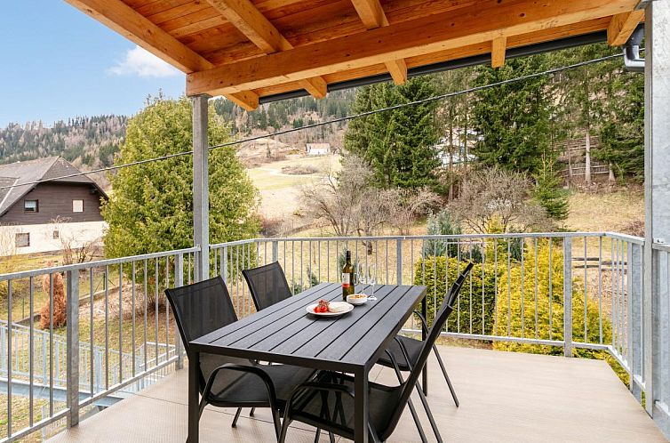 Das Ferienhaus NRV Top 567 XL in Moederbrugg, Steiermark, bietet eine einladende Terrasse und eine malerische Bergkulisse.