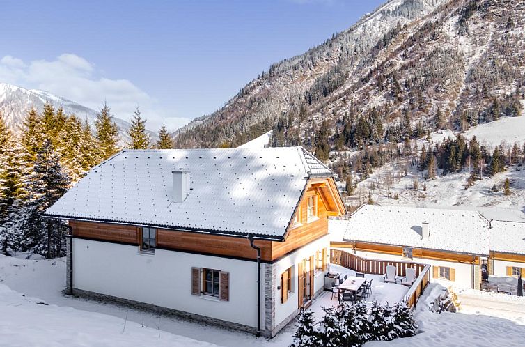 Winterse charme bij chalet Schletski in Donnersbachwald, Steiermark, met uitzicht op besneeuwde bergen en serene natuur.