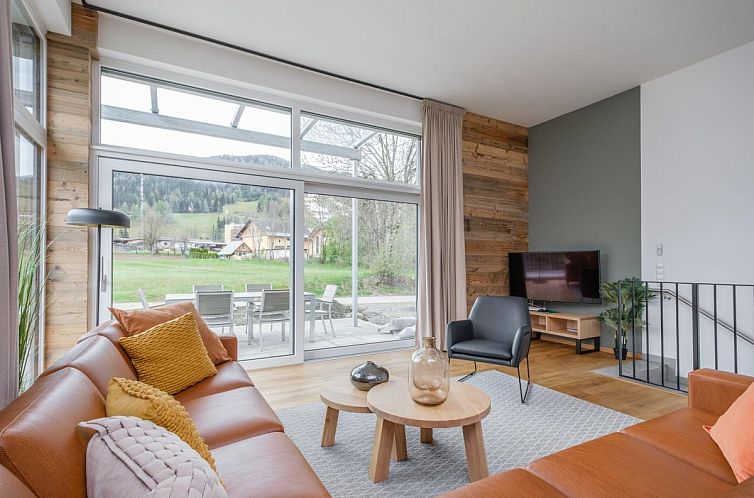 Bright living space of Aquarius Haus 9 TOP 18, vacation accommodation in Kreischberg, Austria, with modern furnishings and views of nature.
