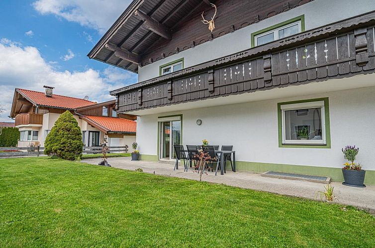 Charmante Terrasse von Kaiser Traum I in Ebbs, Tirol, umgeben von einem ueppigen Garten und einer wunderschoenen Berglandschaft.