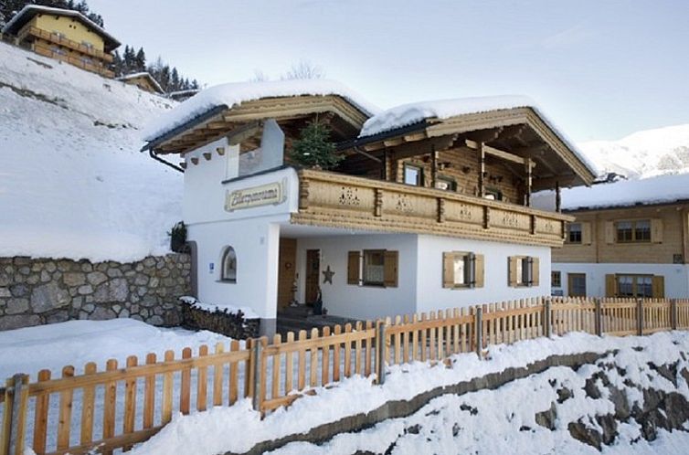 Erleben Sie Winterpracht im Chalet Hainzenberg in Zell am Ziller, Tirol, einem gemuetlichen Chalet inmitten von Schnee.