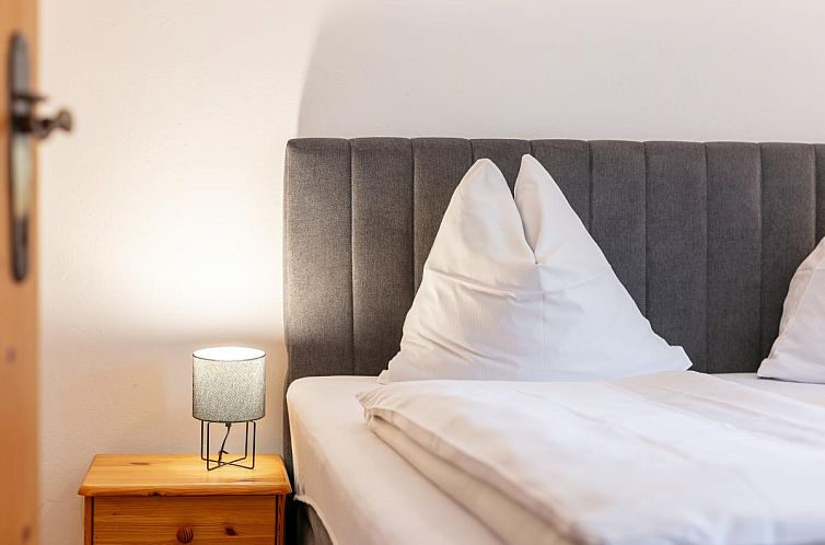 Gezellige slaapkamer van Rettenstein in Kirchberg in Tirol, vakantiehuis met luxe bed en warme ambiance.