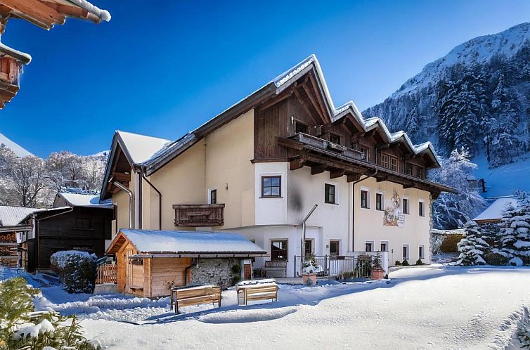 Vacation home Schweizerhof Margrith in Huben, Tyrol, surrounded by snow and mountains, ideal for a peaceful winter vacation.