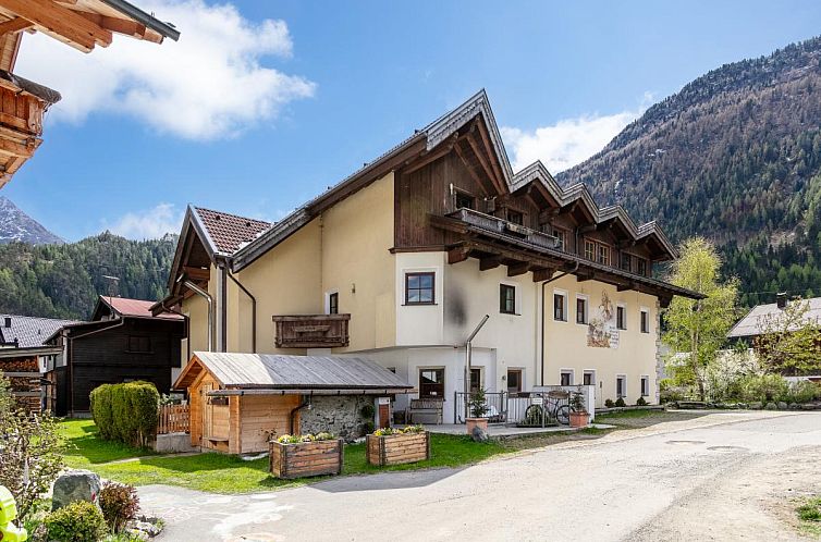 Die stimmungsvolle Unterkunft Schweizerhof Edelweiss in Huben, Tirol, bietet einen herrlichen Blick auf die schneebedeckten Alpen.