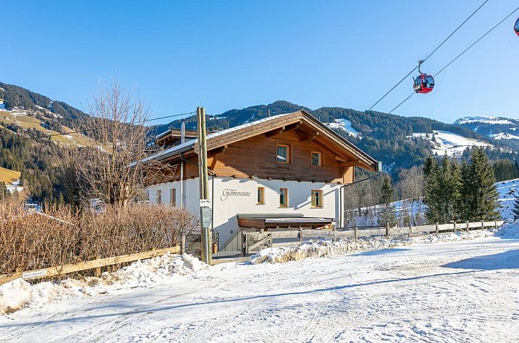 Charming Gamsraute vacation apartment in Auffach, Tyrol, surrounded by snow and mountains with a ski elevator nearby.