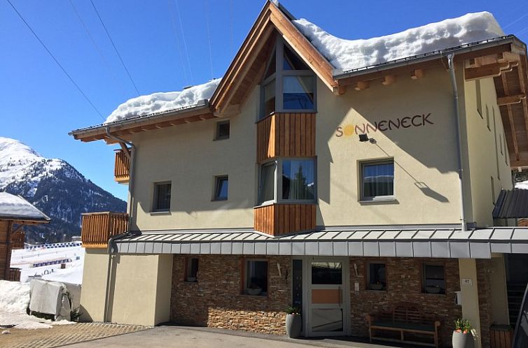 Ferienhaus Haus Sonnenek in St. Anton, Tirol, mit Blick auf schneebedeckte Berge und einen sonnigen Wintertag.