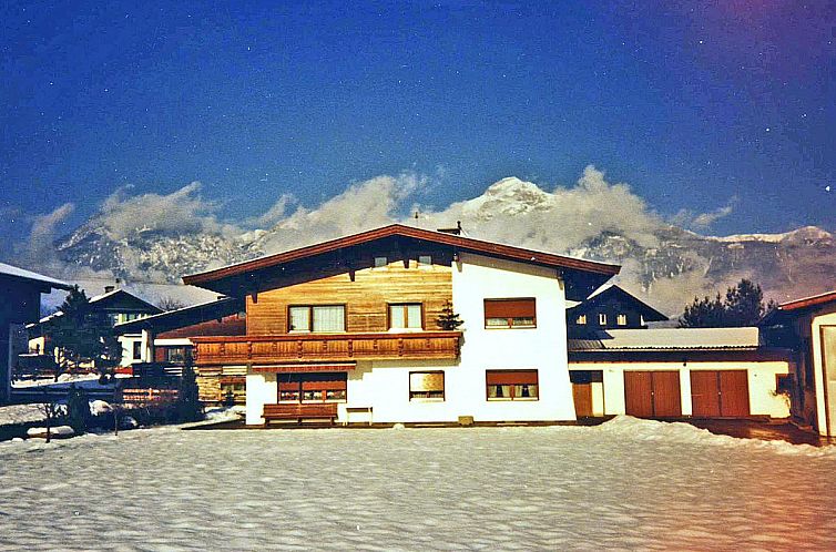 Charmantes Ferienhaus Schlitters in Fuegen, Tirol, umgeben von winterlicher Alpenlandschaft.