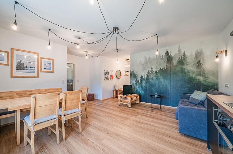 Stylish interior of Tirola Bude Lisi Sepp Top 3-4, vacation accommodation in Hopfgarten im Brixental, Tyrol with modern interior and forest wallpaper.