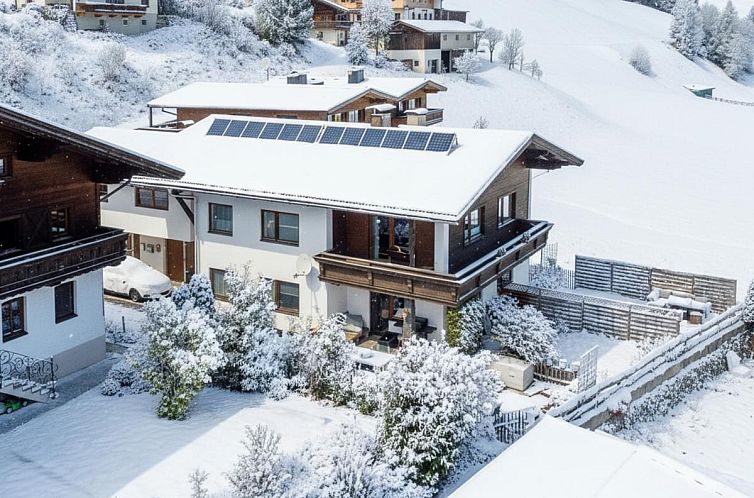 Rustikales Ferienhaus Blumenwiese I und II in Hopfgarten, Tirol, mit Blick auf die schneebedeckten Alpen.