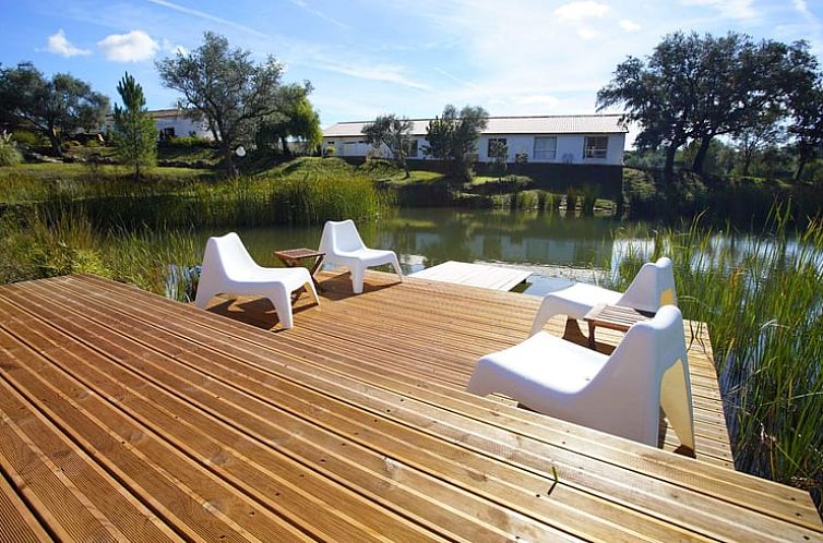 Geniet van het rustige terras bij Vakantiehuisje in Querenca, Algarve, Portugal, met prachtig uitzicht op het omringende water en groen.