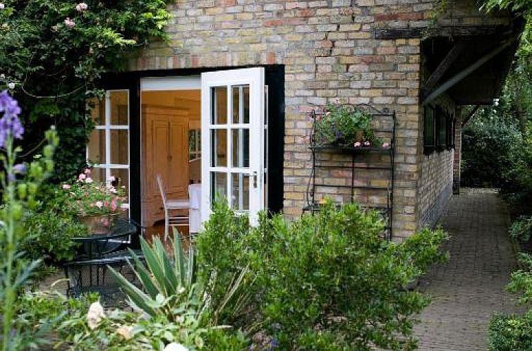 B&B Veerhoeve in Sluis, Zeeland, bietet einen charmanten Aussenbereich mit gruenem Garten und Backsteinfassade.