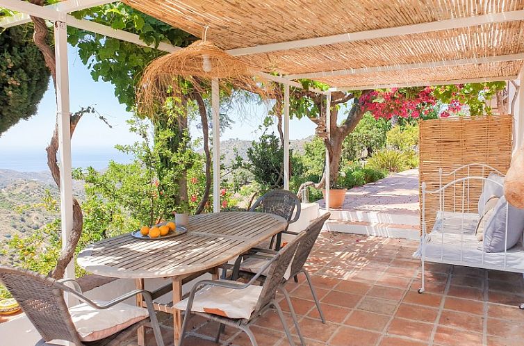Entspannen Sie sich auf der Veranda der Finca la Vida in Competa, Spanien, einem charmanten Ferienhaus inmitten der gruenen Natur.
