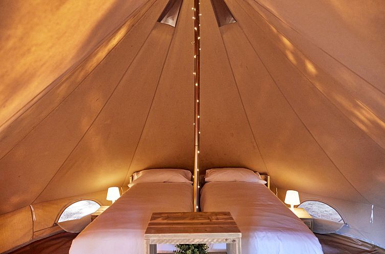 Das Innere der Glamping Bell Marisma in Andalusien, Spanien, zeigt gemuetliche Betten in einer charmanten Glamping-Lodge.