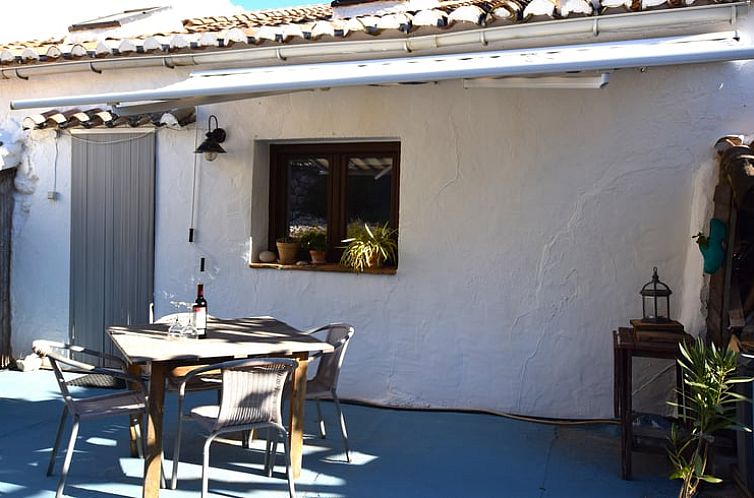 Relax on the veranda of Holiday Home in Alfarnatejo, Andalusia, Spain, overlooking the serene surroundings.