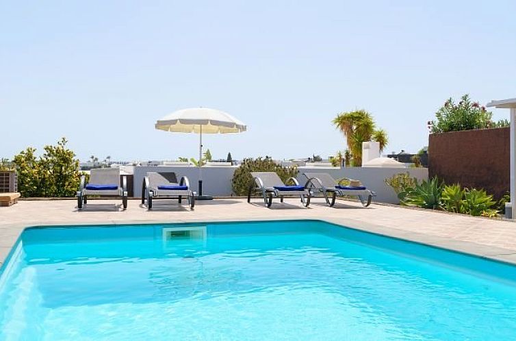 Geniet van de zon bij het zwembad van Villa Benita in Playa Blanca, een luxe vakantiehuis op de Canarische Eilanden.