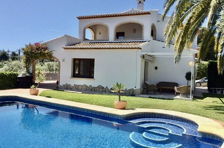 Ferienhaus Gemuetliche Villa mit Meerblick in Javea, Spanien, umgeben von einem ueppigen Garten und einem einladenden Swimmingpool.