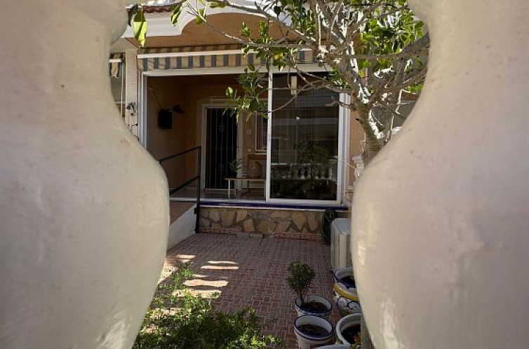 Uitzicht op de charmante patio van Casa Calmate, een vakantiehuis in Ciudad Quesada, Costa Blanca, omgeven door natuur en rust.