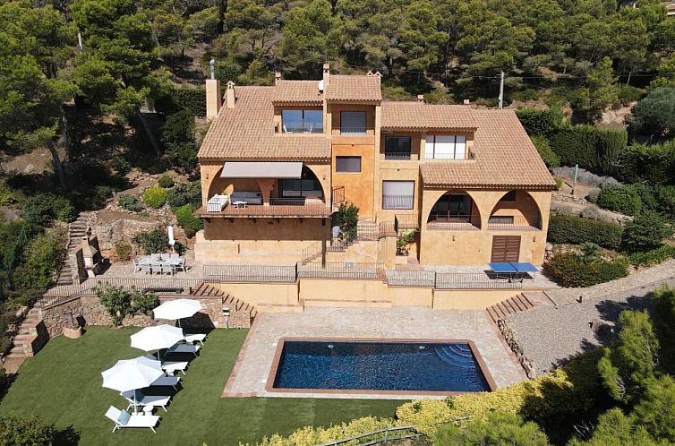 View of Casa Garbi, a vacation home in Begur, Costa Brava, with private pool and green surroundings.