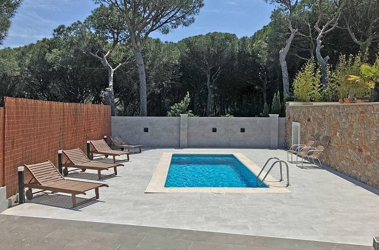 Relax by the pool of Bel Coll, a beautiful vacation home in Escala, Costa Brava, overlooking green forests.