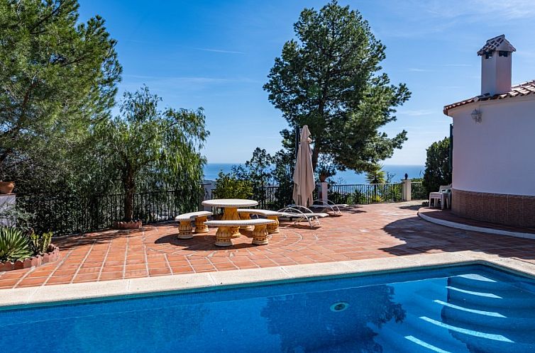 Ontspan op het terras met uitzicht op zee bij House of the Rising Sun, een luxe villa met zwembad in Sayalonga, Spanje.