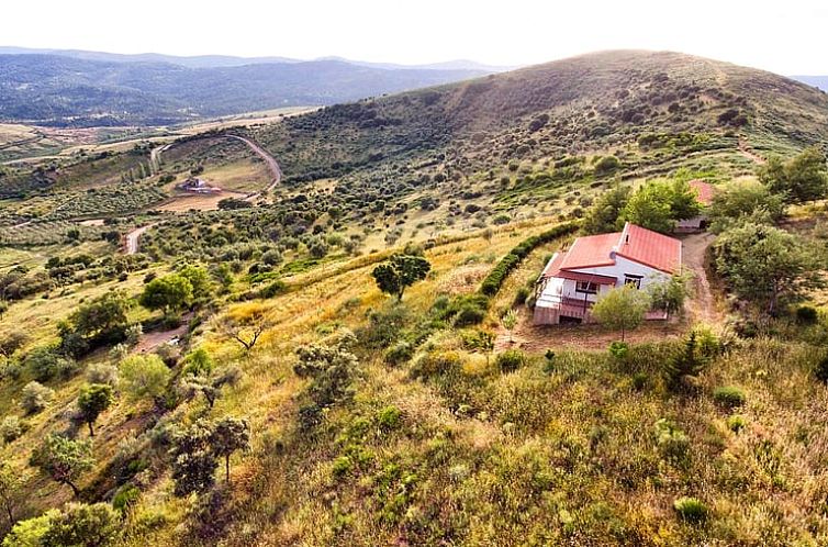 Vakantiewoning Huisje in Berzocana, gelegen in het schilderachtige landschap van Extremadura, Spanje, omgeven door groene heuvels en natuurlijke schoonheid.