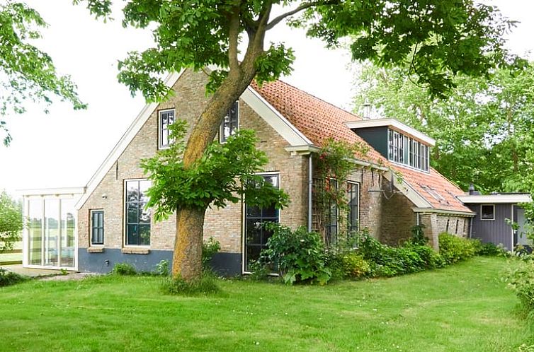 Das Ferienhaus in Kollumerpomp liegt in der gruenen Natur von Lauwersmeer und bietet ein charmantes Aeusseres mit traditioneller friesischer Architektur.