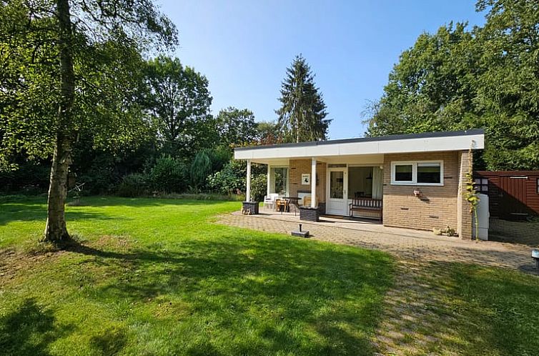 Gezellige woonkamer in Huisje in Schoonloo, vakantiehuis in Midden Drenthe met uitzicht op de groene tuin en comfortabele zitruimte.