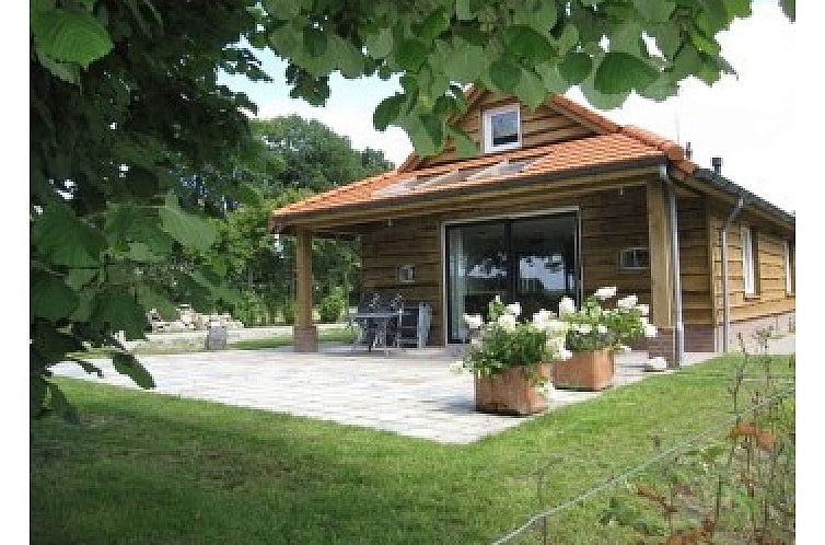 Boerderij het Reestdal in Zuidwolde, charmant vakantiehuis met veranda en bloeiende planten.