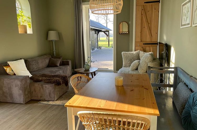 Cozy interior of Holiday Home in Frederiksoord, Southwest Drenthe with comfortable seating area and garden view.