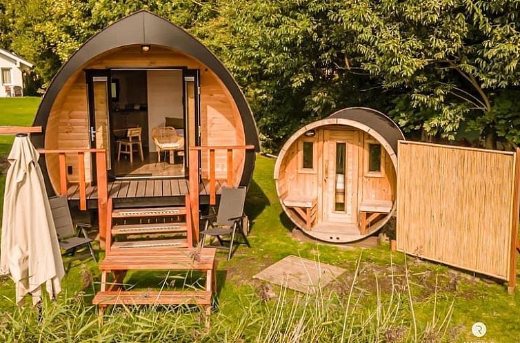 Gezellige houten lodge bij Vakantiehuis in Oostrum/Dokkum, Friesland, omgeven door weelderig groen.