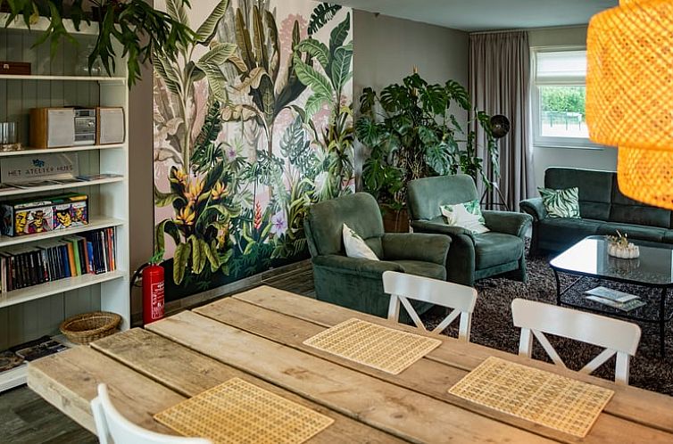 Cozy living room in Cottage in Maasbommel, vacation home in Rivierengebied Gelderland, with green plants and comfortable seating area.