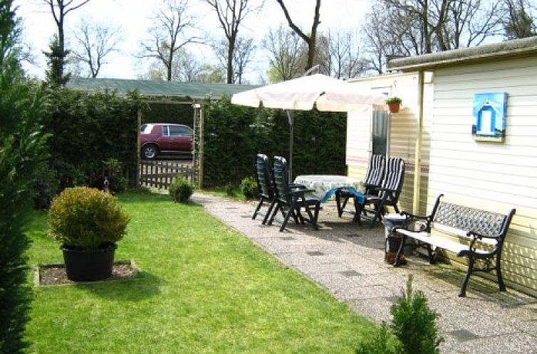 Veranda of Mobile home on the Veluwe in Harskamp, Gelderland with comfortable seating and green garden.